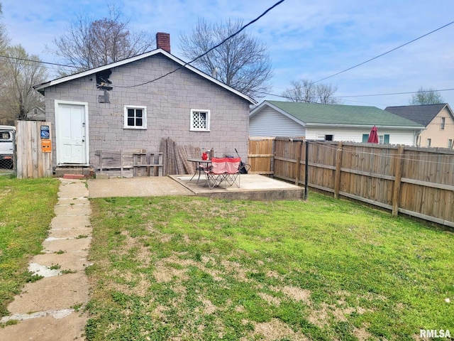 rear view of property with a yard, a patio area, fence, and a chimney