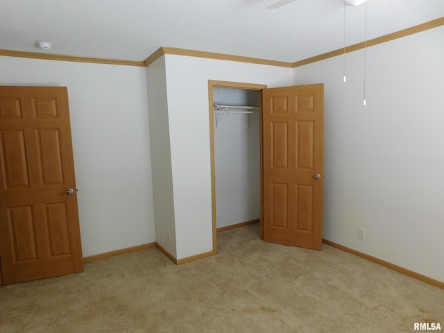 unfurnished bedroom with crown molding, light carpet, ceiling fan, and a closet