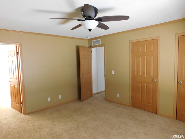 unfurnished bedroom featuring ceiling fan, ornamental molding, and light colored carpet