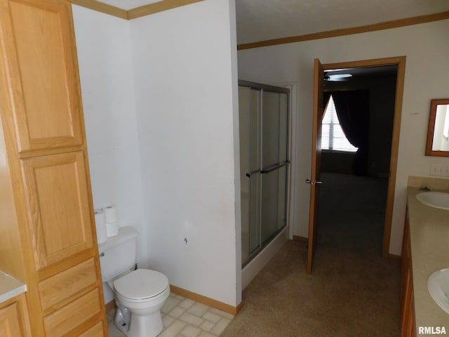 bathroom featuring vanity, ornamental molding, an enclosed shower, and toilet