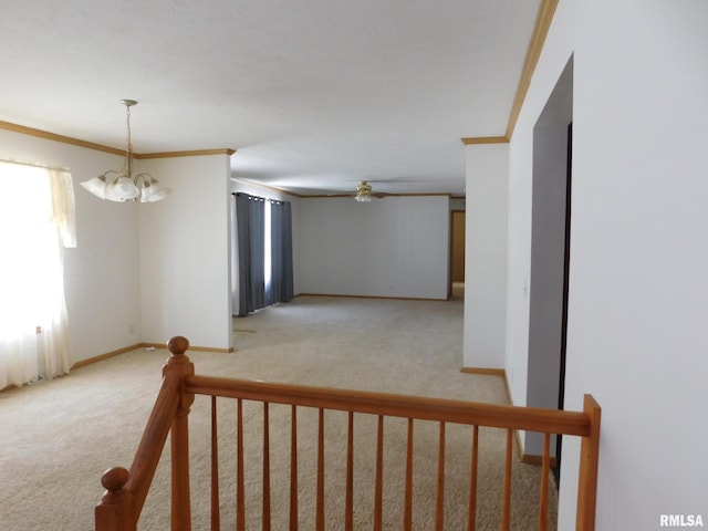 corridor with crown molding, light colored carpet, and a chandelier