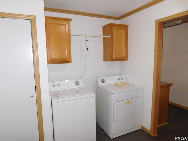 laundry area featuring cabinets, ornamental molding, and washer and clothes dryer