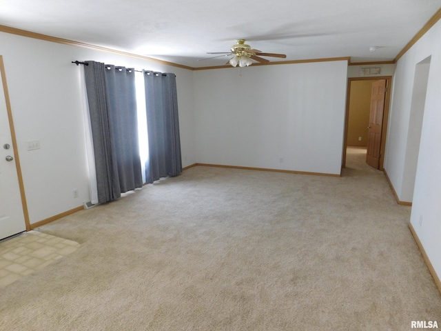 carpeted spare room featuring crown molding and ceiling fan