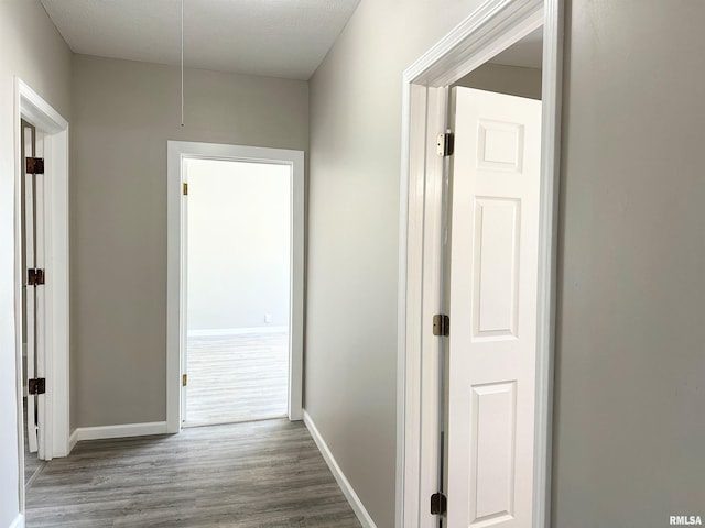 hall featuring a textured ceiling and hardwood / wood-style floors