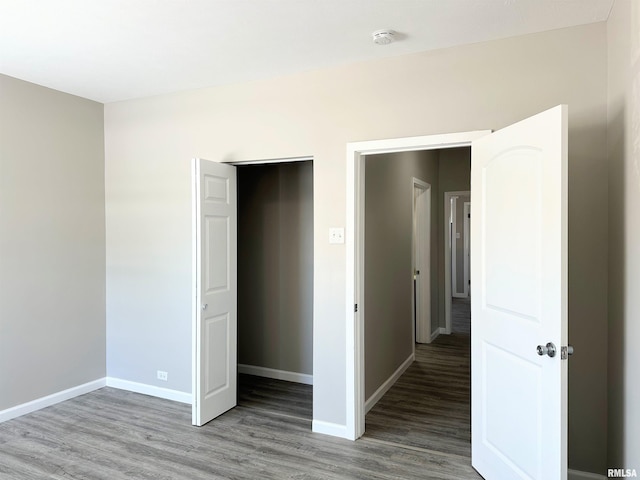 unfurnished bedroom featuring a closet and hardwood / wood-style floors