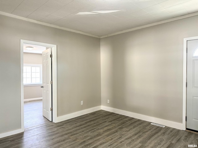 empty room featuring dark hardwood / wood-style flooring and ornamental molding