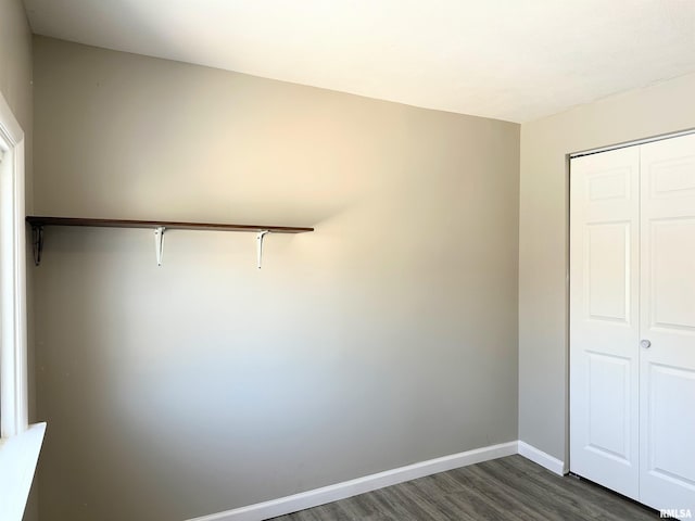 unfurnished bedroom with a closet and dark hardwood / wood-style flooring