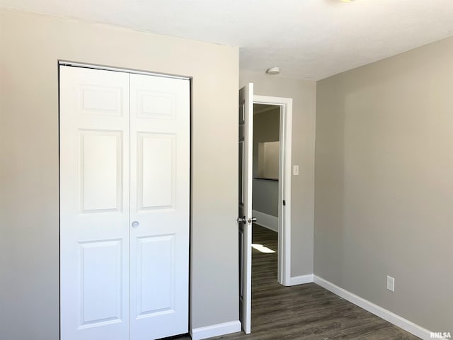 unfurnished bedroom featuring a closet and dark hardwood / wood-style floors