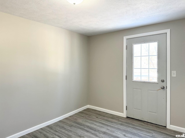 doorway with a textured ceiling and hardwood / wood-style flooring