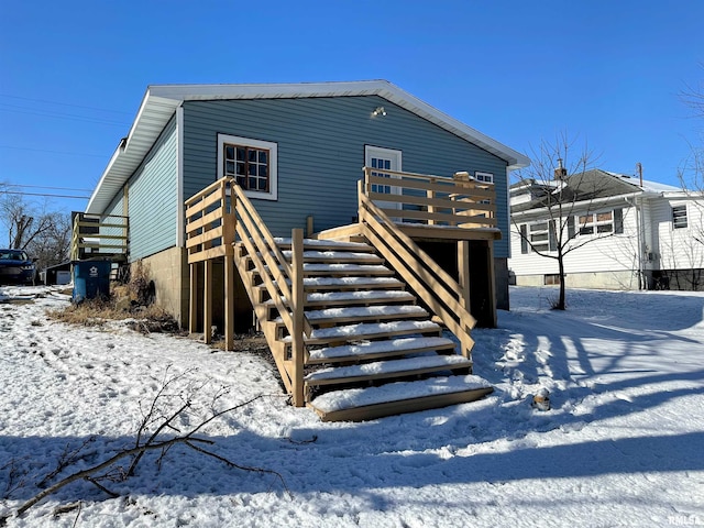 snow covered property with a deck