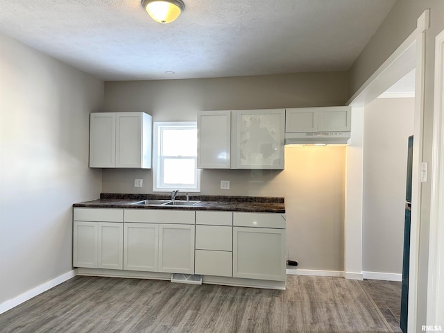 kitchen featuring sink, a textured ceiling, and white cabinets