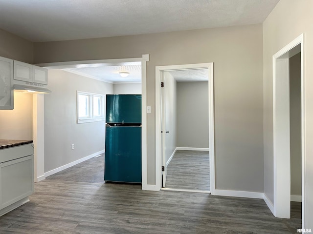 kitchen featuring dark wood-type flooring, fridge, and white cabinetry