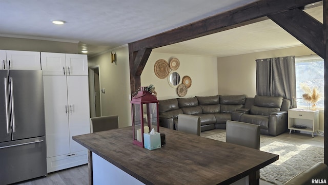 dining room with crown molding and light hardwood / wood-style floors