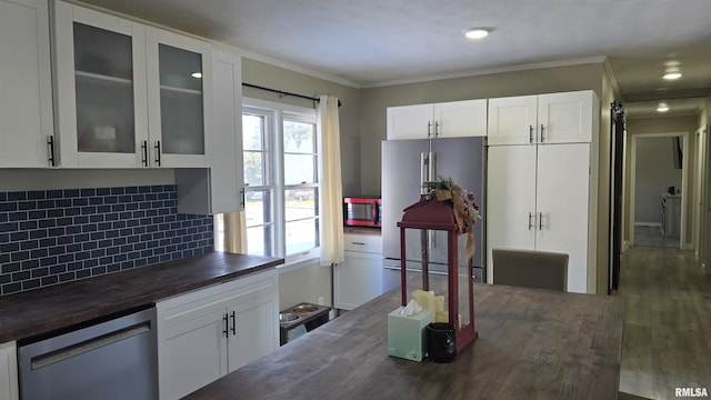 kitchen with backsplash, appliances with stainless steel finishes, wood counters, and white cabinetry