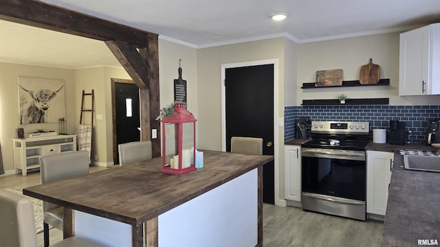 kitchen with tasteful backsplash, crown molding, white cabinetry, light wood-type flooring, and stainless steel range with electric stovetop