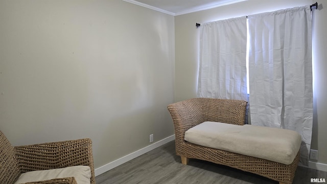 sitting room featuring ornamental molding and wood-type flooring