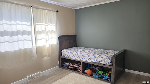 bedroom featuring hardwood / wood-style floors and ornamental molding