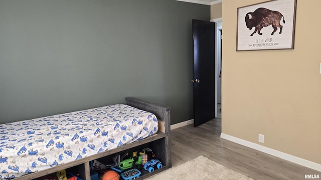 bedroom with crown molding and wood-type flooring