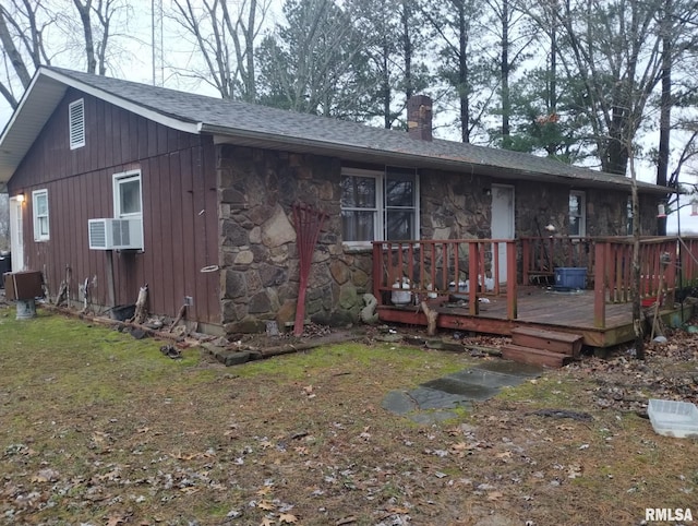 view of front of house with a wooden deck, cooling unit, and a front lawn