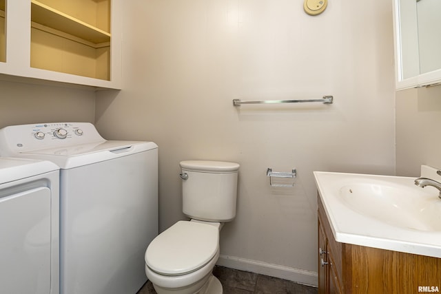 bathroom featuring toilet, vanity, and washer and dryer