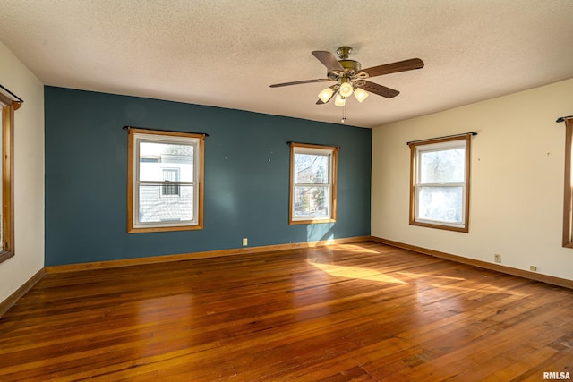 empty room with ceiling fan, hardwood / wood-style floors, and a textured ceiling