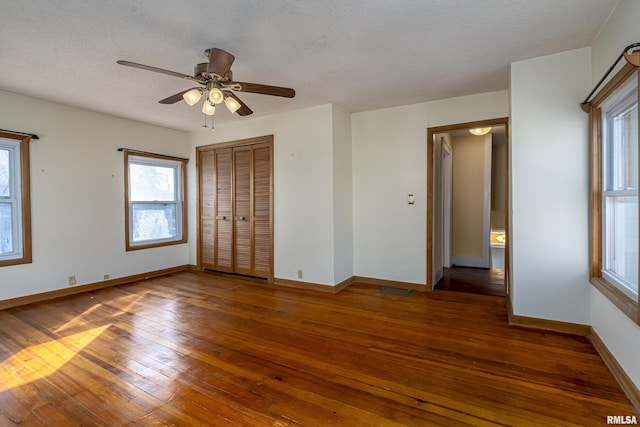 unfurnished bedroom featuring a textured ceiling, ceiling fan, and dark hardwood / wood-style floors