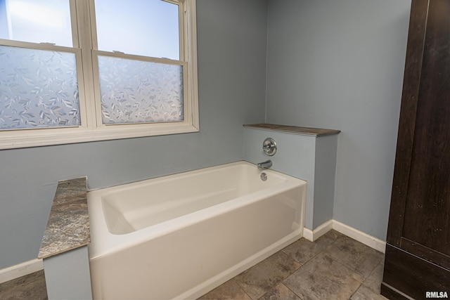 bathroom with a tub and tile patterned floors