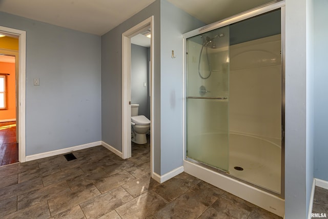 bathroom with toilet and an enclosed shower