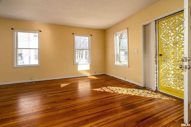 interior space featuring a textured ceiling and hardwood / wood-style floors