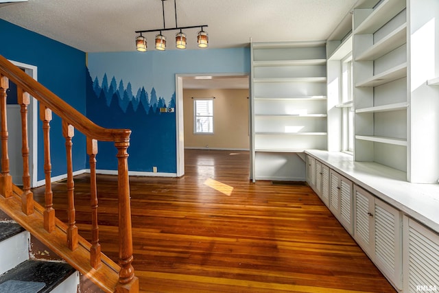 interior space featuring a textured ceiling, dark hardwood / wood-style flooring, and built in features