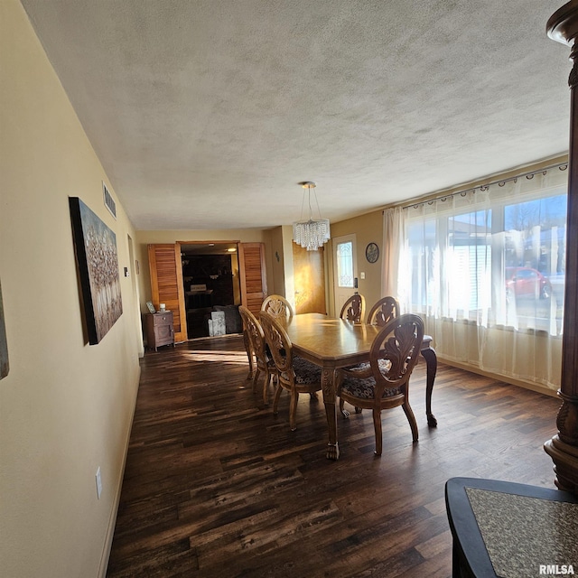 dining area with dark wood-type flooring and a notable chandelier