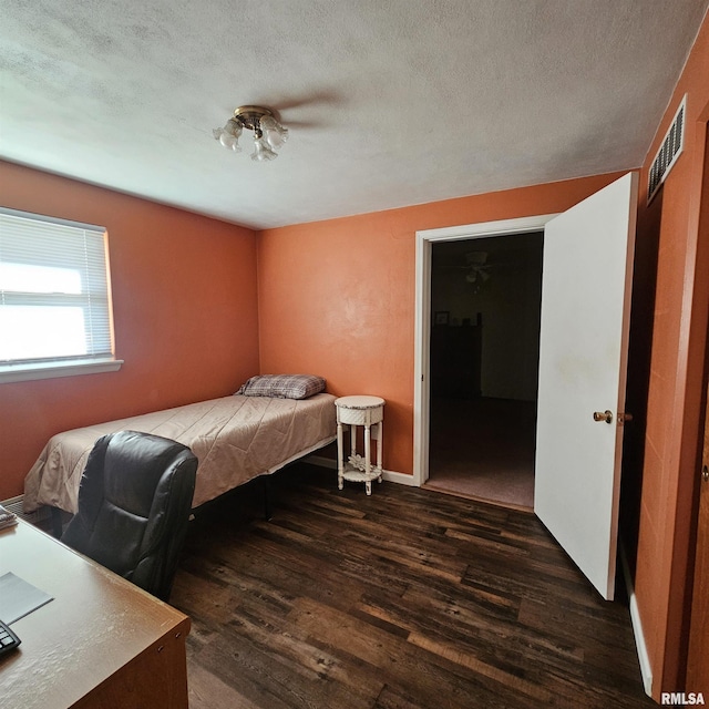 bedroom featuring a textured ceiling and dark hardwood / wood-style floors