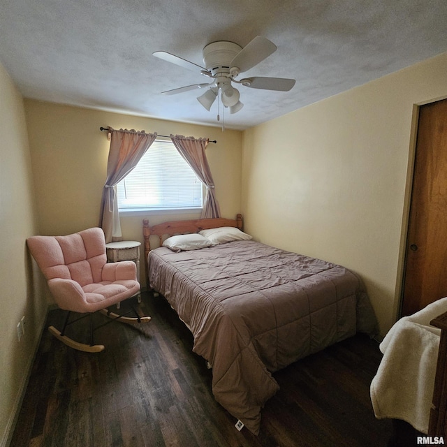 bedroom with ceiling fan, a textured ceiling, and dark hardwood / wood-style floors