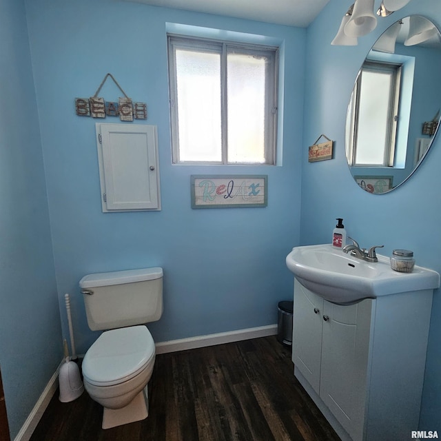 bathroom with wood-type flooring, toilet, and vanity