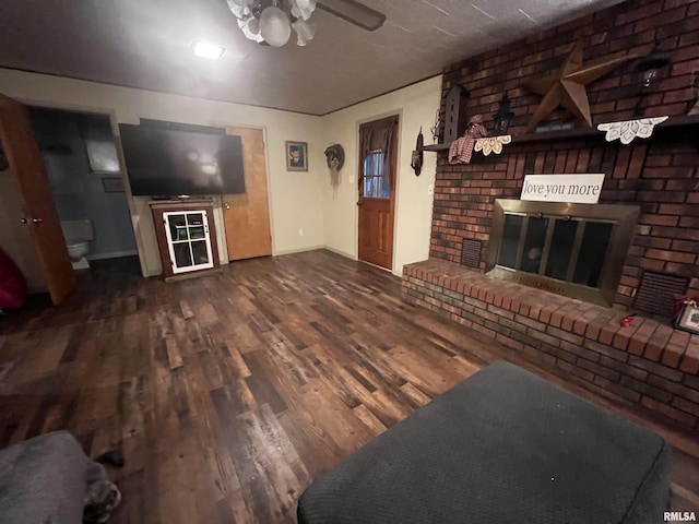 living room featuring a brick fireplace, hardwood / wood-style flooring, and ceiling fan