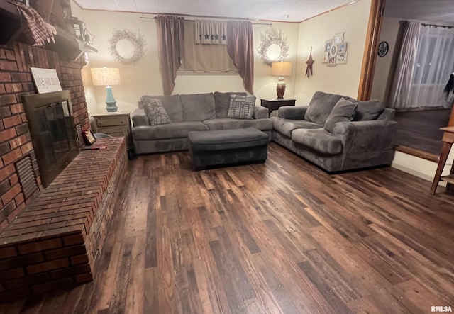 living room featuring dark hardwood / wood-style flooring, crown molding, and a fireplace