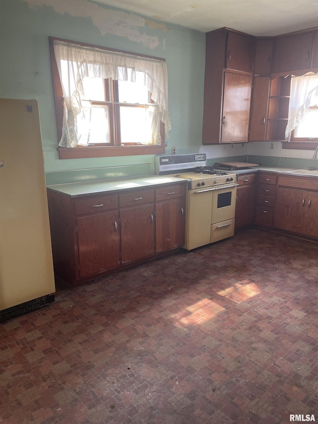 kitchen featuring double oven range, light countertops, freestanding refrigerator, and open shelves