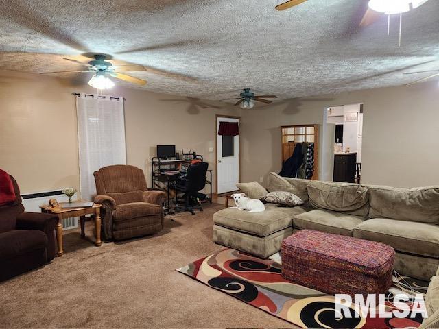 carpeted living room featuring ceiling fan and a textured ceiling