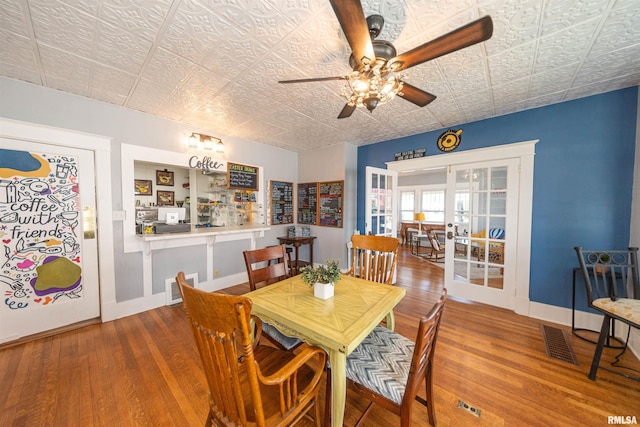 dining space featuring ceiling fan, wood-type flooring, and french doors