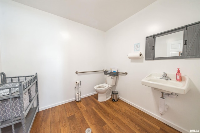 bathroom featuring sink, wood-type flooring, and toilet