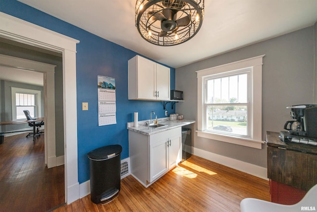 kitchen with white cabinetry, ceiling fan, sink, light wood-type flooring, and black appliances