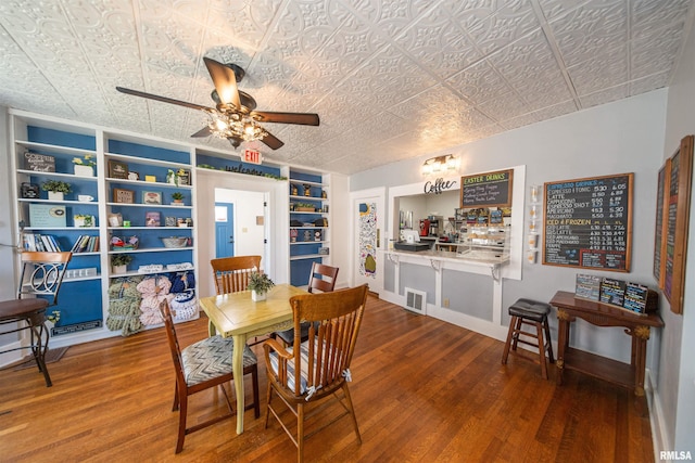 dining area featuring ceiling fan, wood-type flooring, and built in shelves