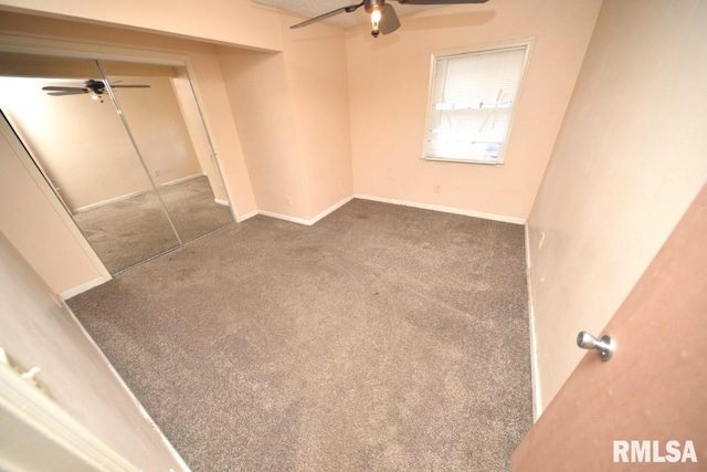 unfurnished room with ceiling fan and dark carpet