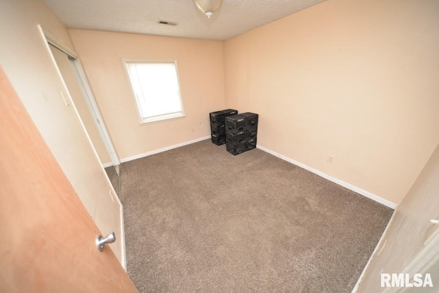 carpeted spare room with a textured ceiling