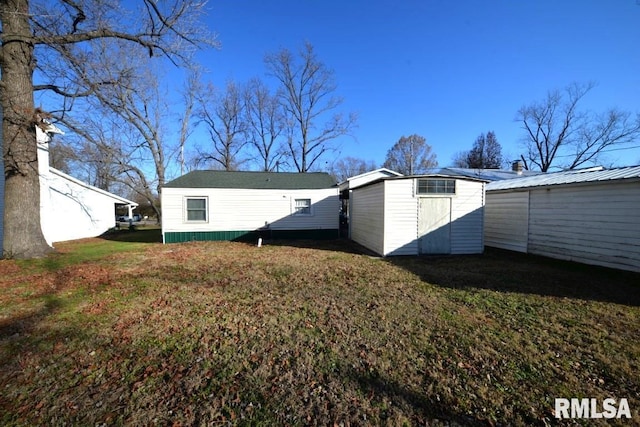 back of property with a shed and a yard