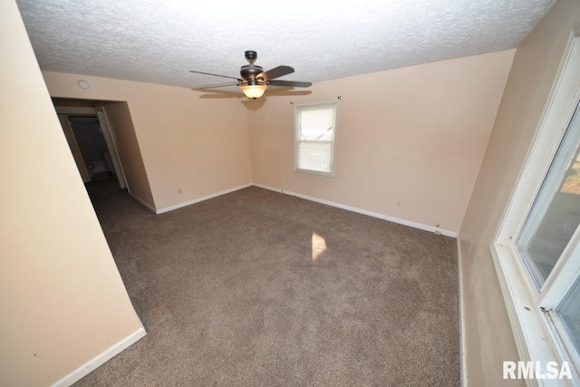 carpeted spare room with a textured ceiling and ceiling fan