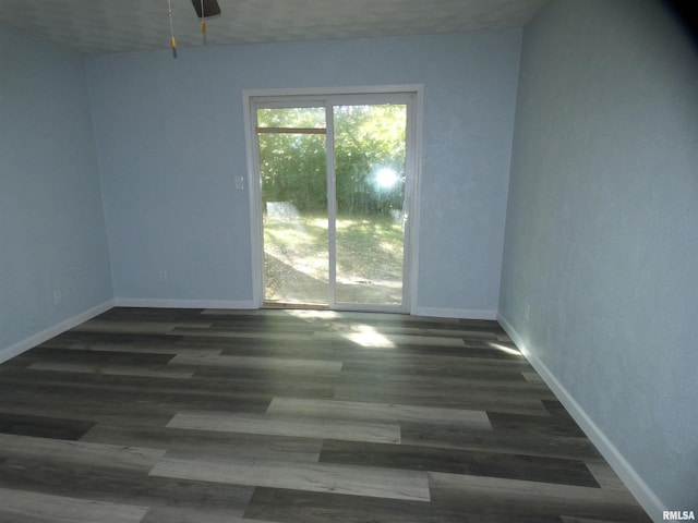 spare room with ceiling fan and dark hardwood / wood-style floors