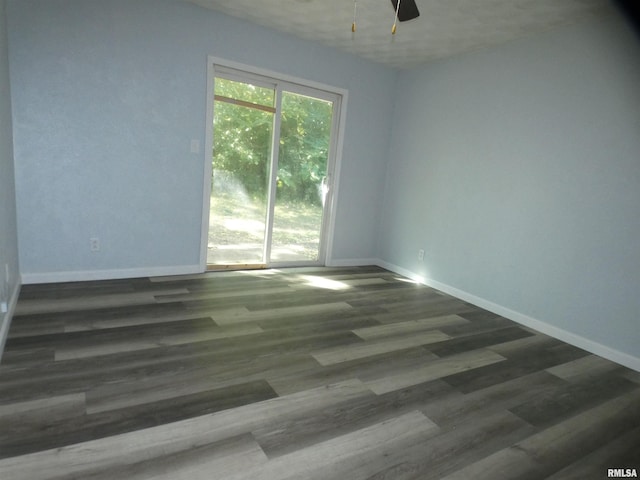 unfurnished room featuring dark wood-type flooring and ceiling fan