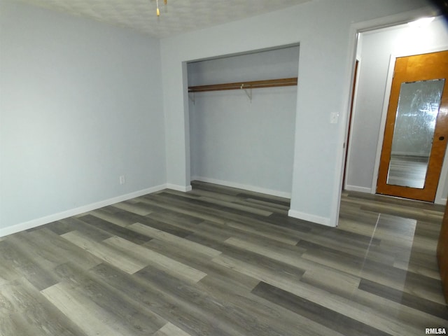 unfurnished bedroom featuring dark hardwood / wood-style flooring and a closet