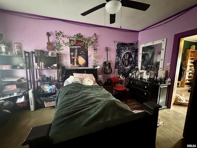 bedroom with ceiling fan, wood-type flooring, and lofted ceiling